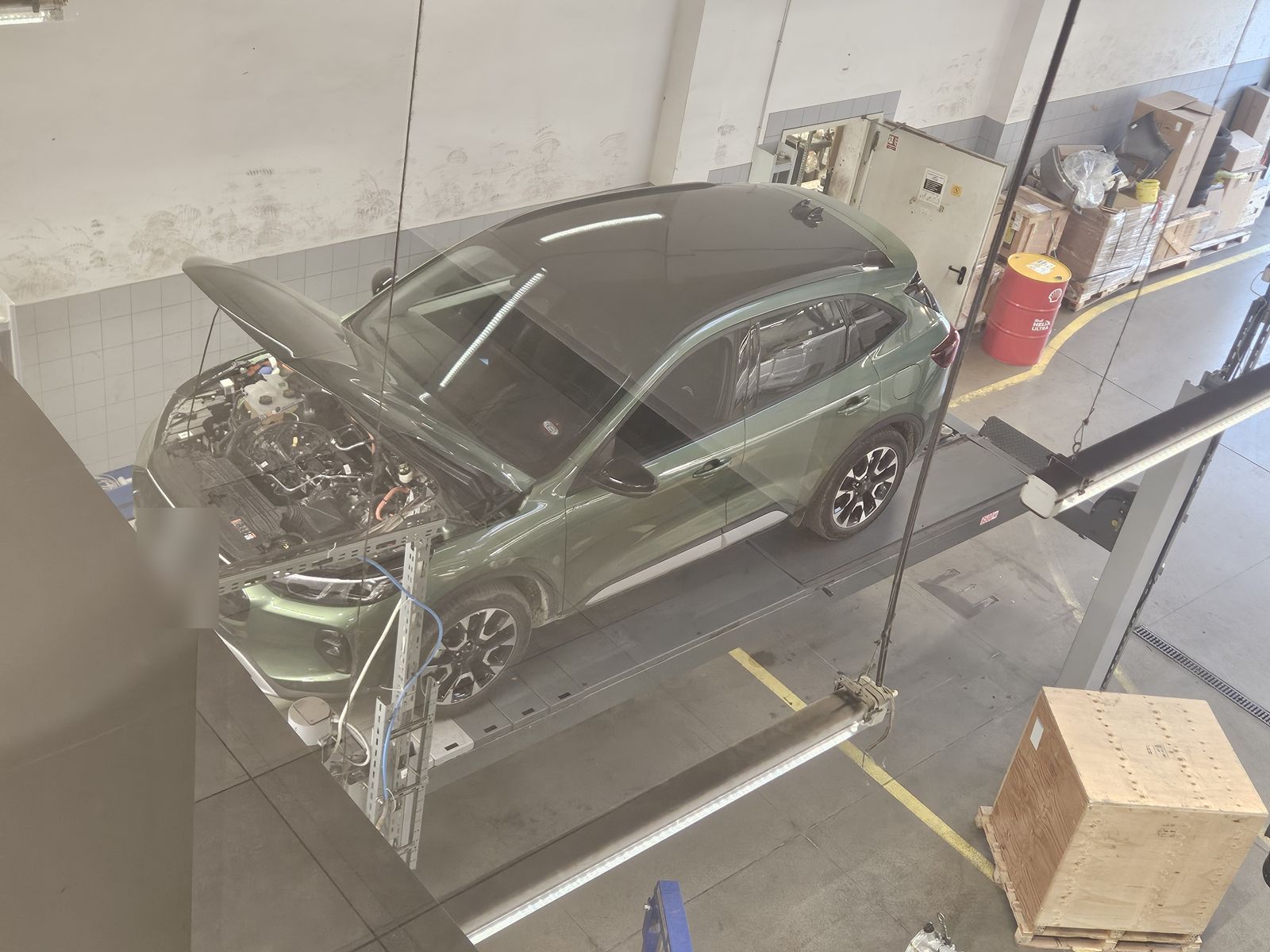 Ford Kuga z otwartą maską na stanowisku w serwisie